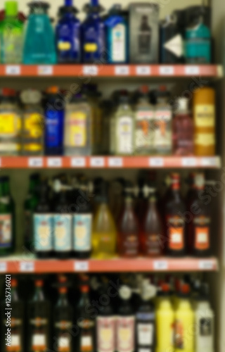 Blurred image of shelves with alcoholic drinks in supermarket.