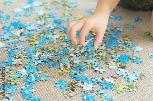 Child hand taking puzzle piece