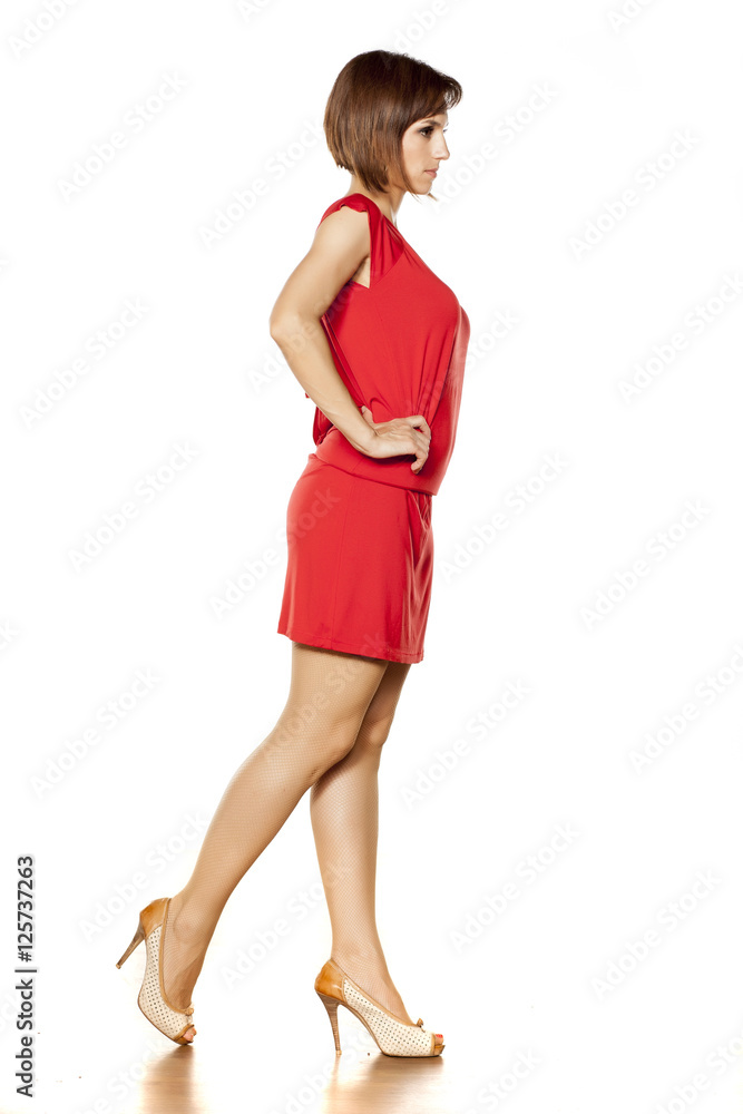 full figure of middle aged woman in short red dress. side view full figure of middle aged woman in short red dress. side view