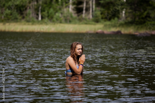 Girl preparing to dive in a Swedish lake surrounded by dense pin