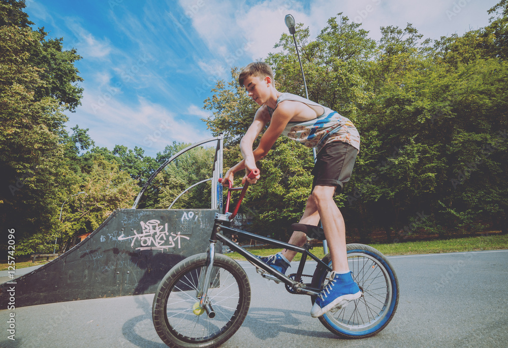Boy riding a bmx in a park. Stock Photo | Adobe Stock
