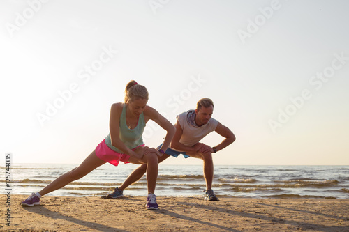 Runners stretching by the sea after workout