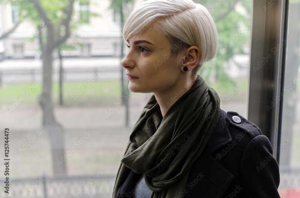 Young blonde girl walking on the city