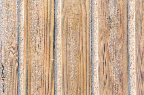 Hoarfrost slowly melting on the wooden boards in the morning sun heat. Wooden background. Vertical lines.