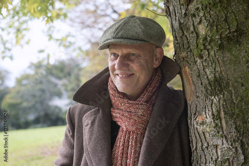 Close up portrait image of a happy mature man outdoors in autumn. 