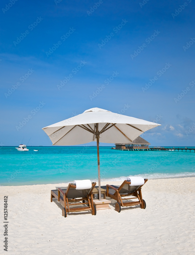 beach chairs with white umbrella at the ocean front