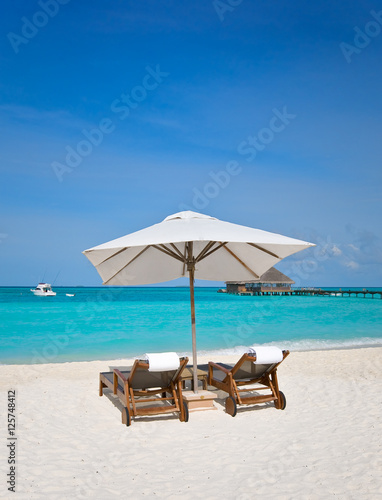 beach chairs with white umbrella at the ocean front