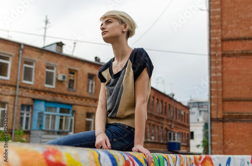 Young blonde girl walking on the city