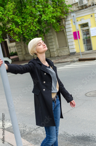 Young blonde girl walking on the city