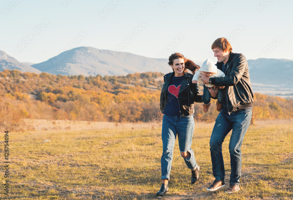 Happy young family having fun outdoors in autumn park. Happy young family having fun outdoors in autumn park.