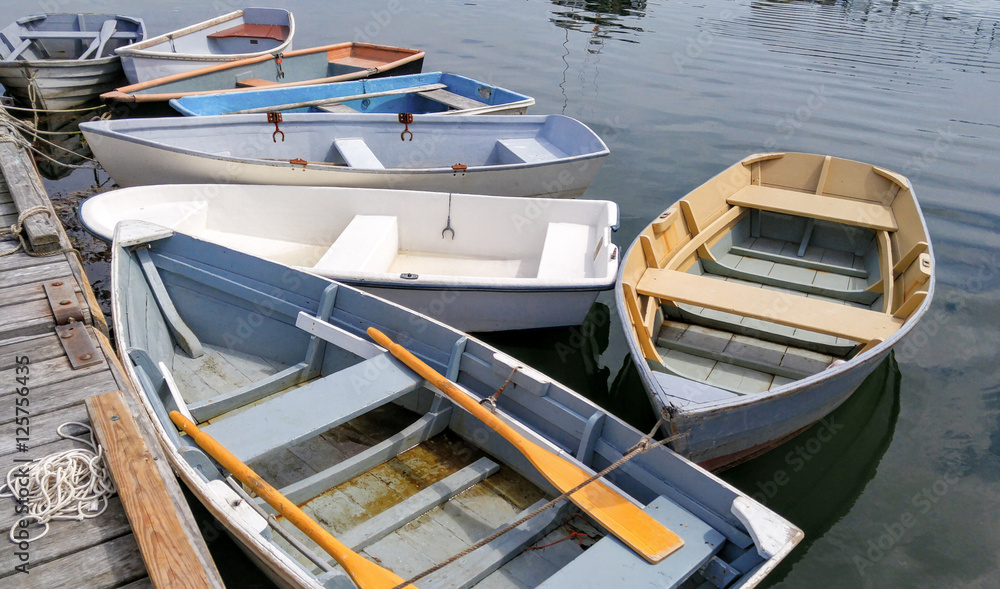 Small Boats at a Dock:  Several rowboats tied to a wooden pier sit quietly on bay in Maine.
