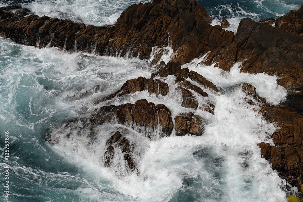 Ocean waters crashing into rocks