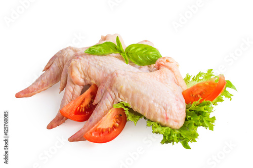 Chicken wings with basil, tomato and lettuce. On white, isolated background.