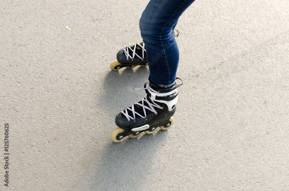 Naklejka premium Young girl with rollers in the park