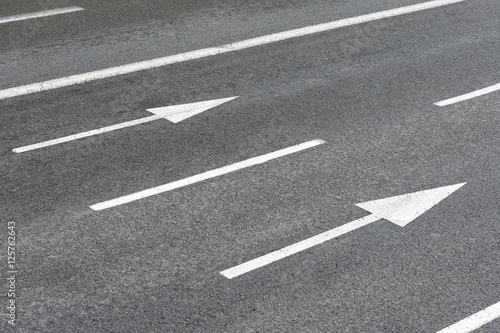 two white arrows signs on an urban asphalt road