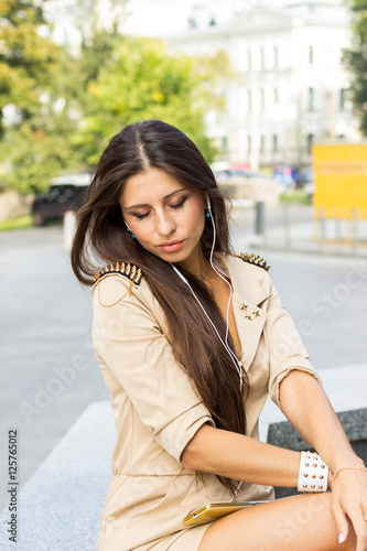 woman listenign to music on the street © retoncy