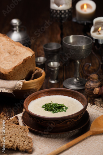 Creamy mushroom soup with herbs on  background of authentic dish