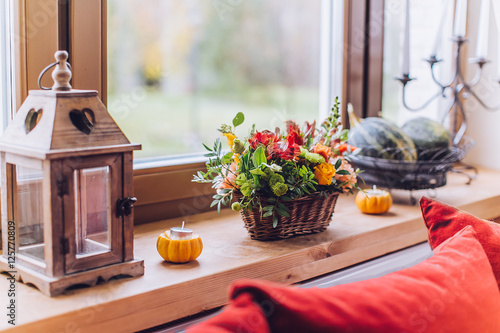 Window sill decorated with pumpkins and a flowerpot