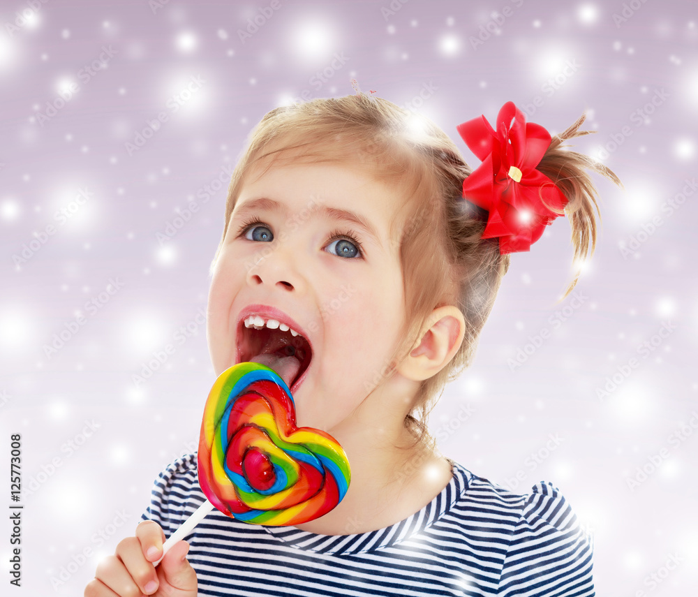 Girl licks candy on a stick