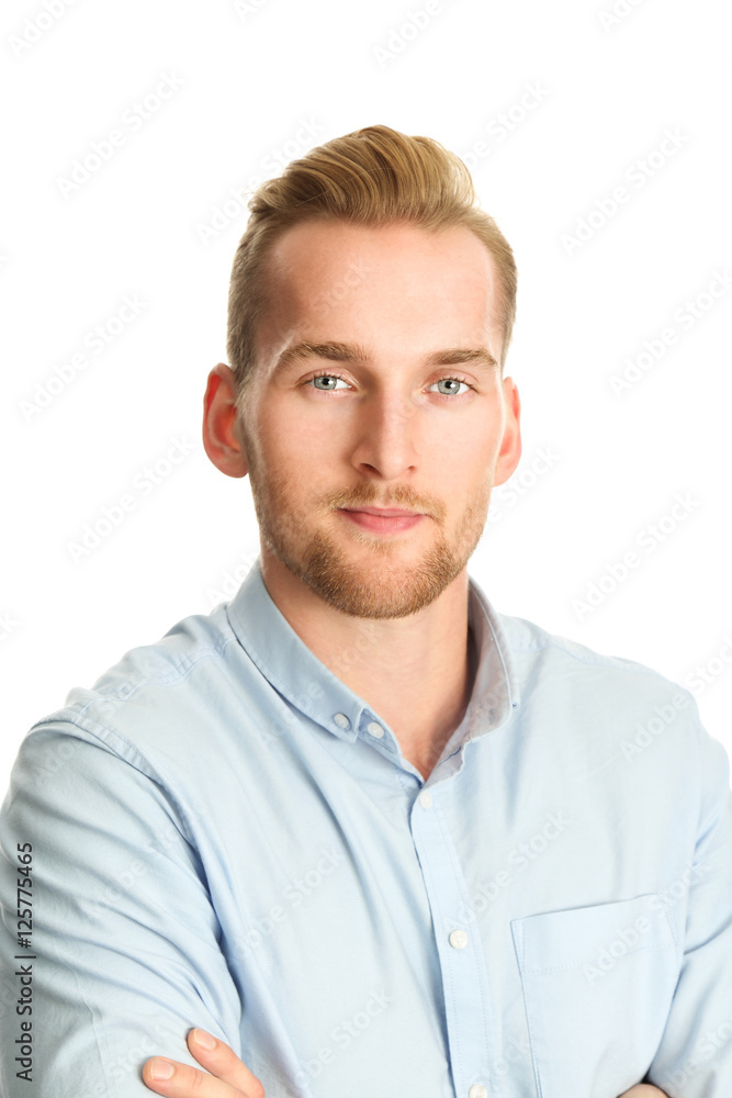 A handsome man in his 20s standing against a white background, wearing a blue shirt tucked in to his khaki pants. Smiling towards camera. A handsome man in his 20s standing against a white background, wearing a blue shirt tucked in to his khaki pants. Smiling towards camera.