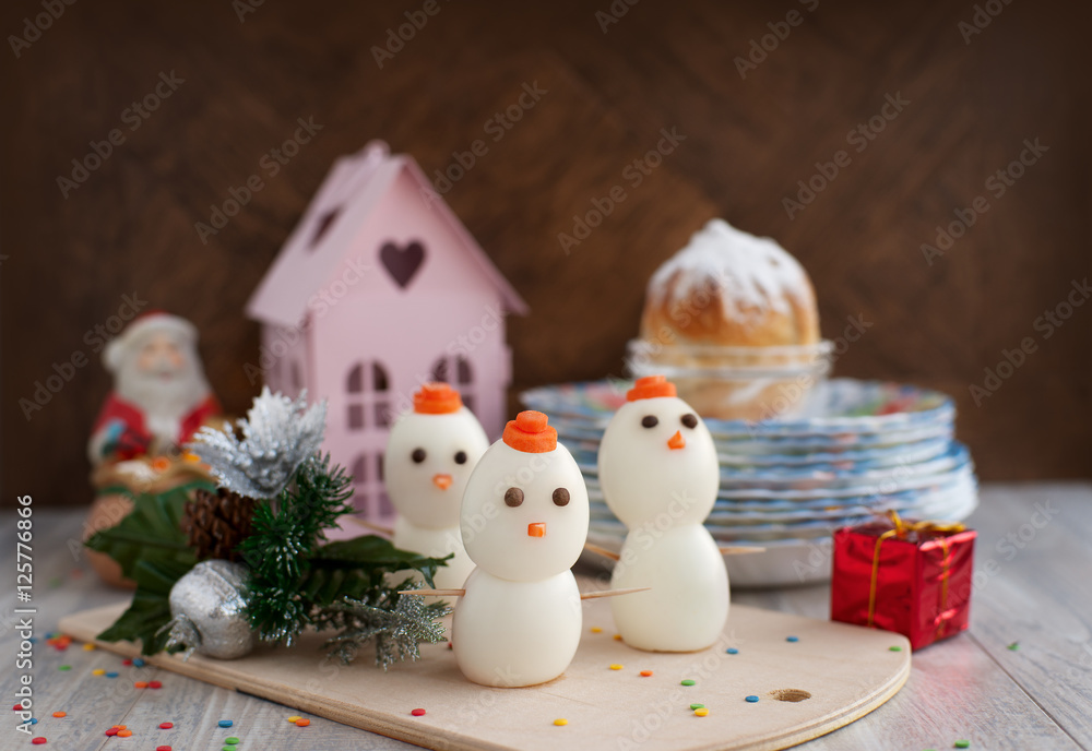 New Year. Snowmen made of chicken eggs and are on the holiday table. A dish of eggs to meet the new year. Snowman is the symbol of winter. Table layout. New Year. Snowmen made of chicken eggs and are on the holiday table. A dish of eggs to meet the new year. Snowman is the symbol of winter. Table layout.