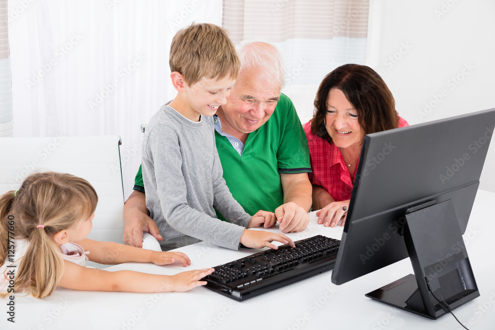 Multi Generation Family Using Desktop Together At Home Multi Generation Family Using Desktop Together At Home