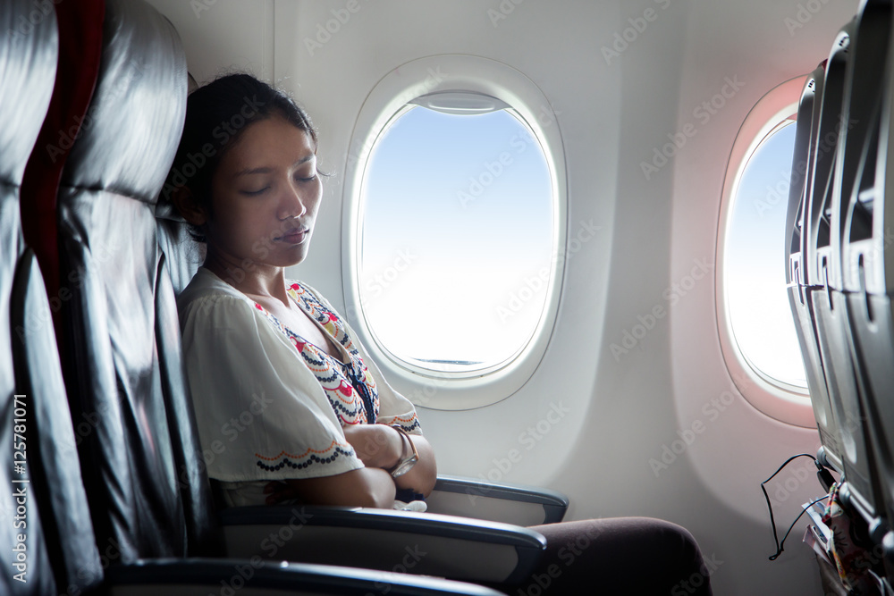 Naklejka premium woman sleeping in an airplane