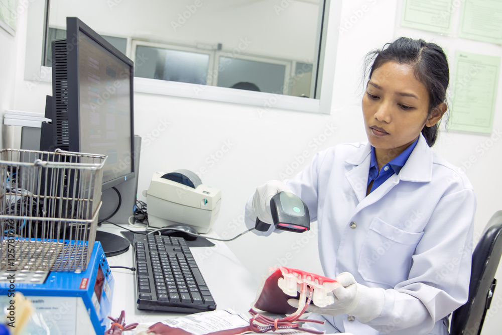 Doctor scanning data from the blood bags Doctor scanning data from the blood bags