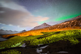 The Aurora Borealis over the mountains range of Stodvarfjordur town in East Iceland.