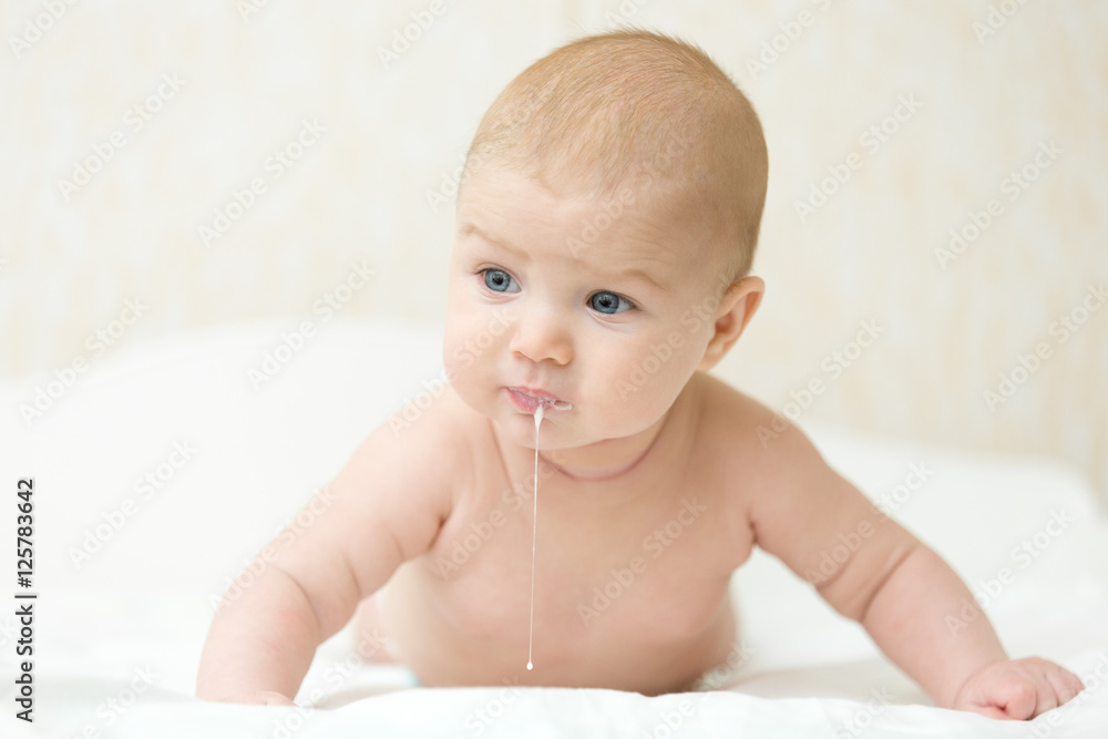 Cute baby raises chest, after eating to release excess gas, turning head put on tummy, good head and arms control, strong. Family, baby development concept photo, lifestyle Cute baby raises chest, after eating to release excess gas, turning head put on tummy, good head and arms control, strong. Family, baby development concept photo, lifestyle