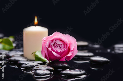 Pink rose with candle ,green leaf and therapy stones 