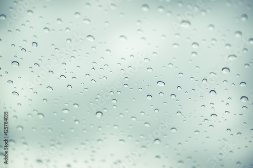 Rain drop on car glass in background.