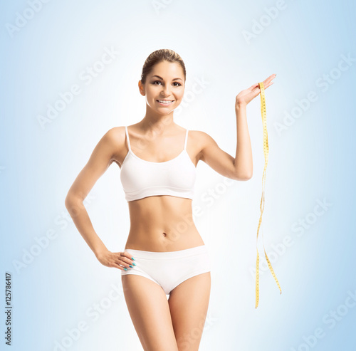 Young and fit woman holding a measuring tape