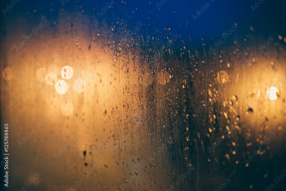 Abstract background of blurred lights through steamy window with