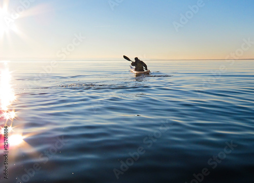 Kayaking at sunset on calm lake © watcherfox