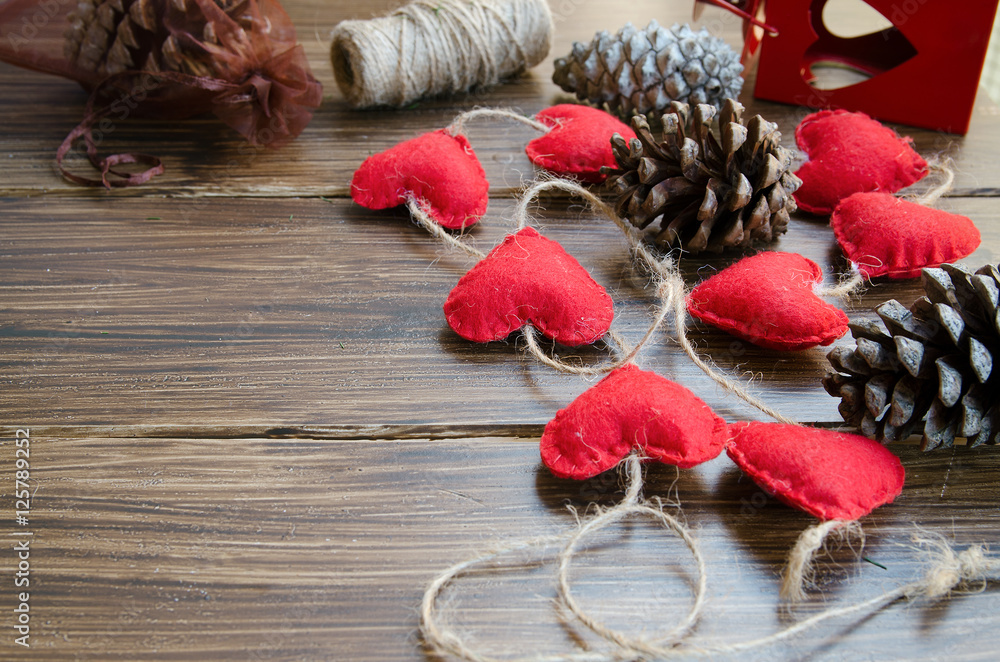 Christmas or New Year background. Making decoration for fir tree, felt heart garland and bobbins on wooden rustic table. Winter holidays concept. Copy space. Christmas or New Year background. Making decoration for fir tree, felt heart garland and bobbins on wooden rustic table. Winter holidays concept. Copy space.