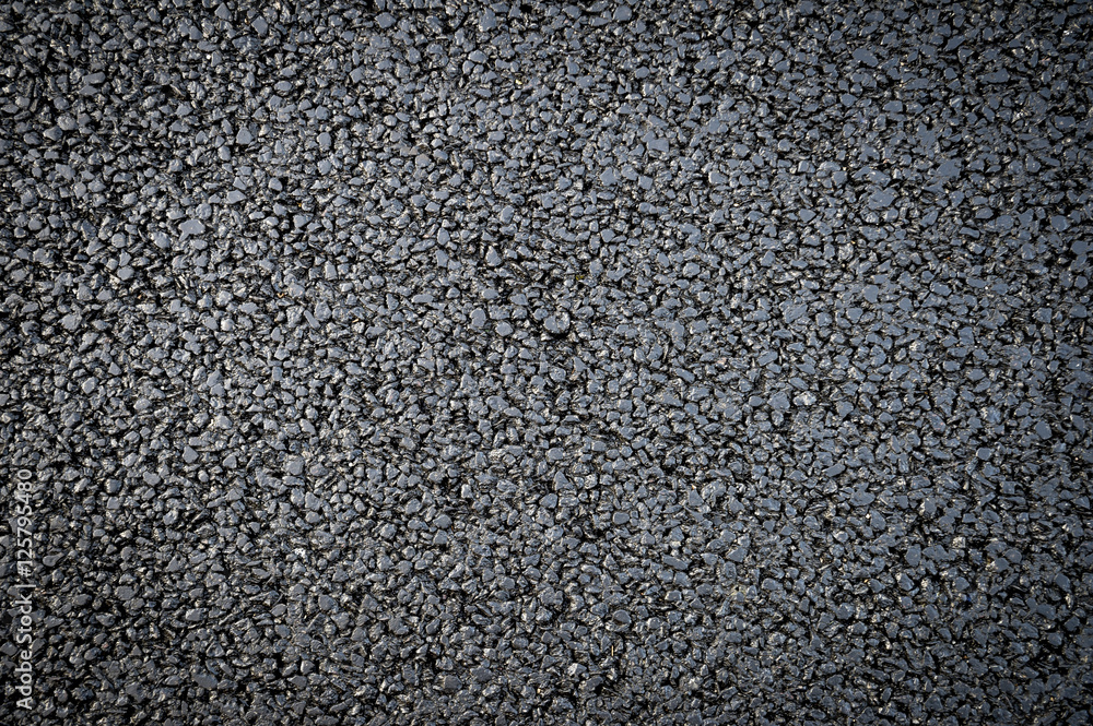 Fresh black asphalt in a textured close-up full frame background Fresh black asphalt in a textured close-up full frame background
