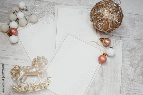 decorated christmas pink, white, gold balls and toy and laying gift cards on Christmas and 2017 New Year on white wooden vintage background photo