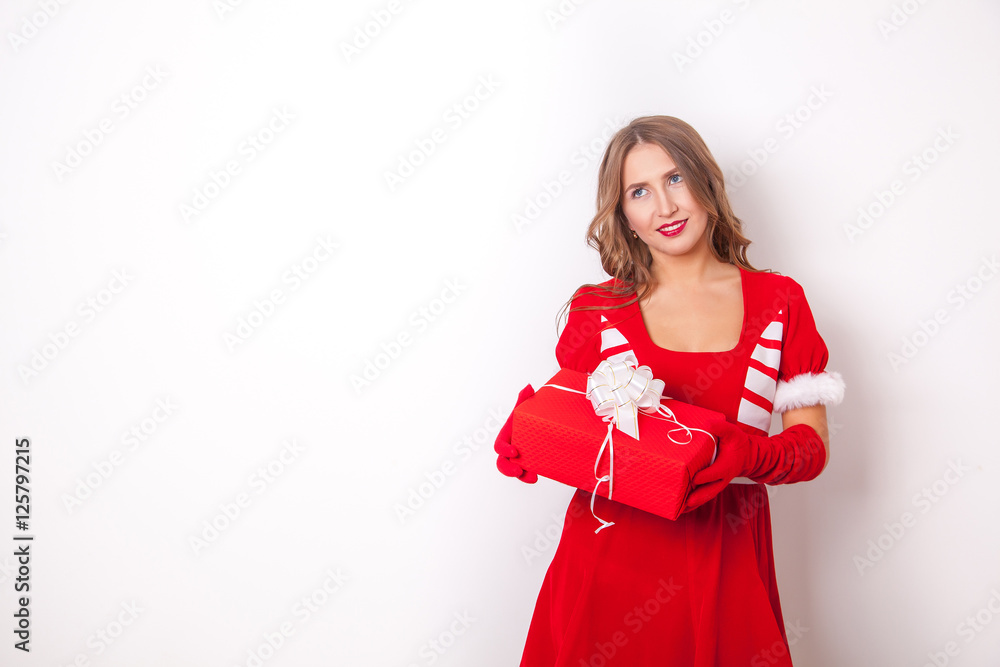Fototapeta premium Beautiful girl wearing santa claus clothes with christmas gift