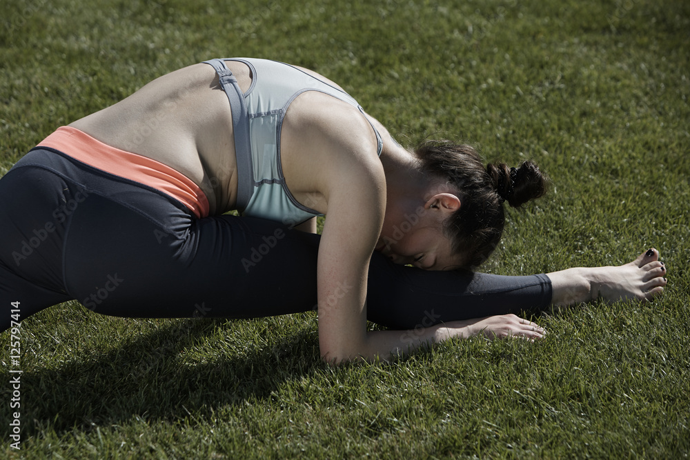 Fototapeta premium Stretching on grass in park