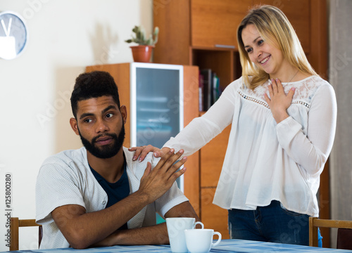 White girl and afro guy trying make out after argue photo