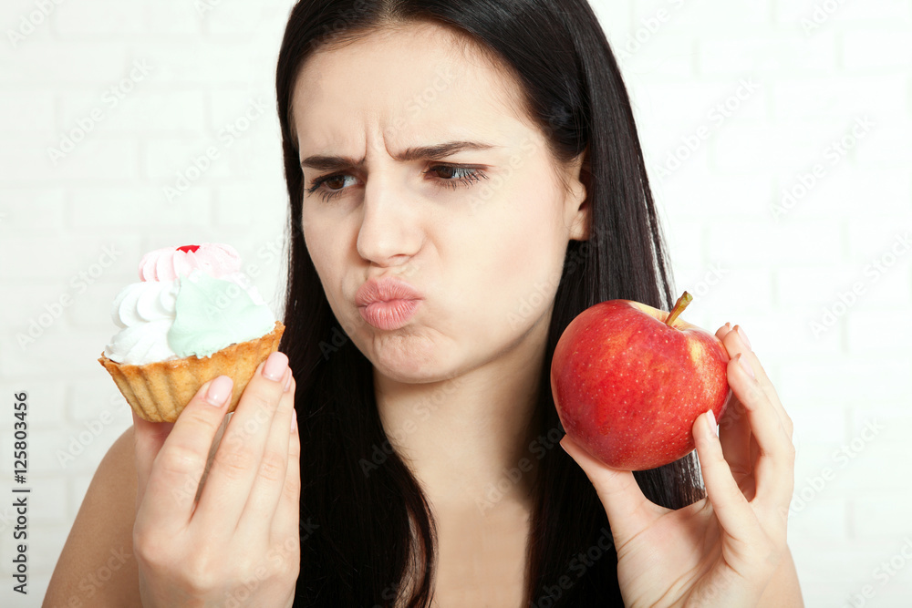 Woman with apple closeup face. Beautiful women exists to clean skin on the face that chooses to eat an apple or cake.Concept of natural food. Asian woman. Woman with apple closeup face. Beautiful women exists to clean skin on the face that chooses to eat an apple or cake.Concept of natural food. Asian woman.
