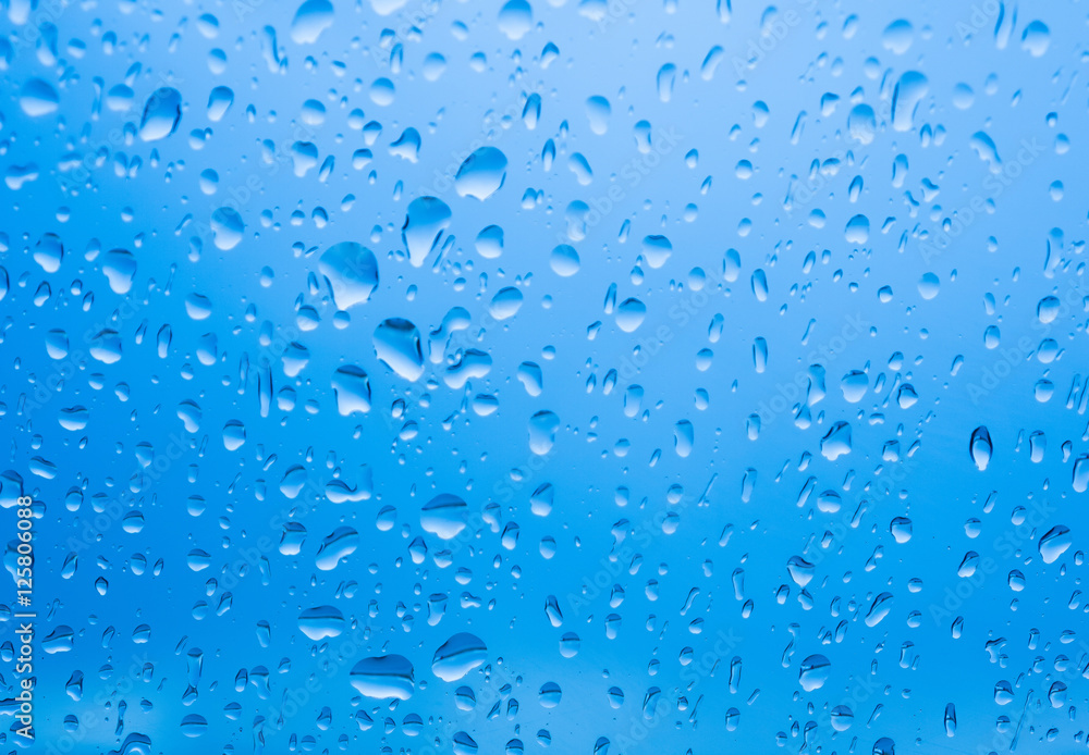 Raindrops on glass with blue light background, Drops of rain on blue glass 