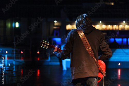 young rock musician on stage playing guitar