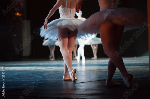 Ballerinas in the movement. Feet of ballerinas close up.