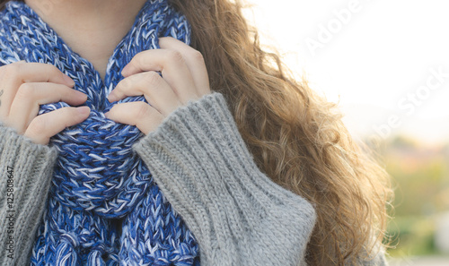 Woman putting blue scarf at park