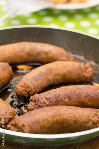 Fried homemade sausages in the frying pan