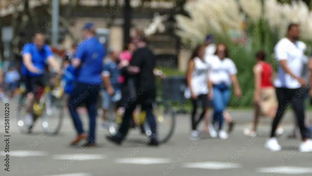 Three quarter view, tourists pedestrians blurred crossing a street in the city of Barcelona in summer.Slow Motion Three quarter view, tourists pedestrians blurred crossing a street in the city of Barcelona in summer.Slow Motion