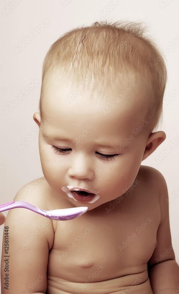 The small child, eats from a spoon The small child, eats from a spoon