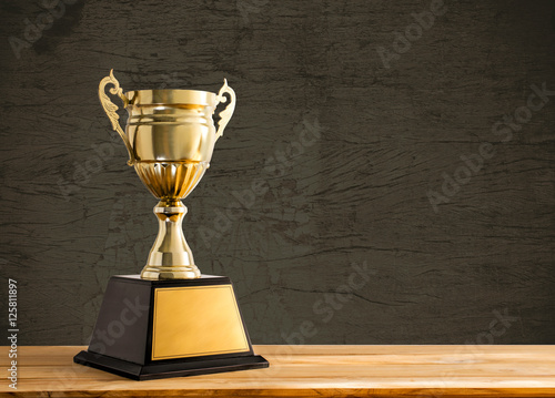 champion golden trophy on wood table with copy space, copy space